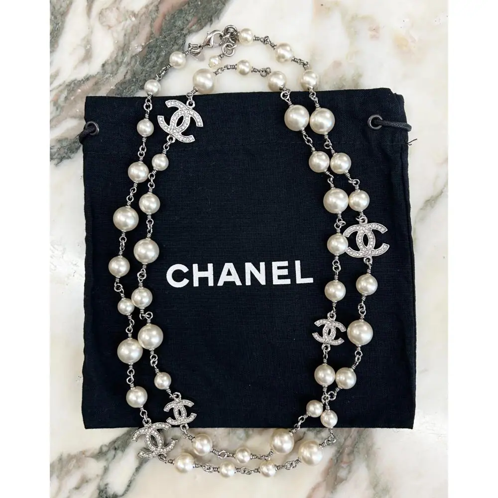 Chanel 2011 long pearl necklace with crystal logo charms