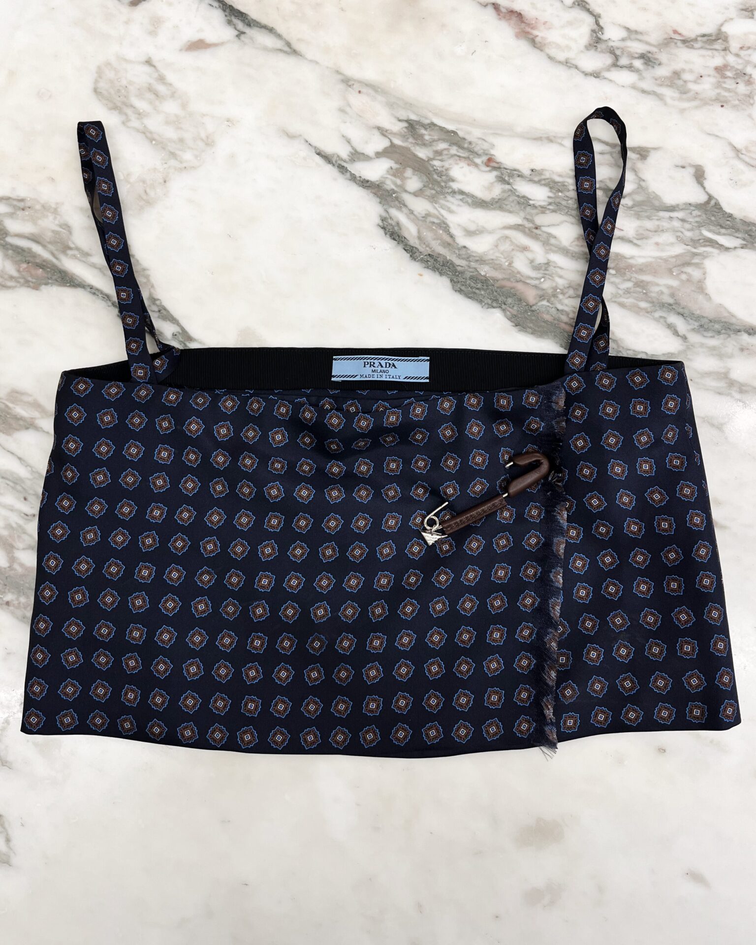 Prada silk twill top with leather wrapped logo pin